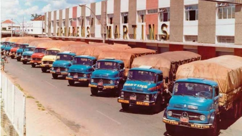 A logística do Martins nos anos 80. Caminhões azuis estacionados na porta dos Armazéns Martins.