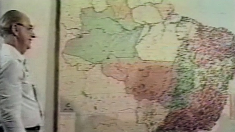 Alair Martins olhando mapa do Brasil