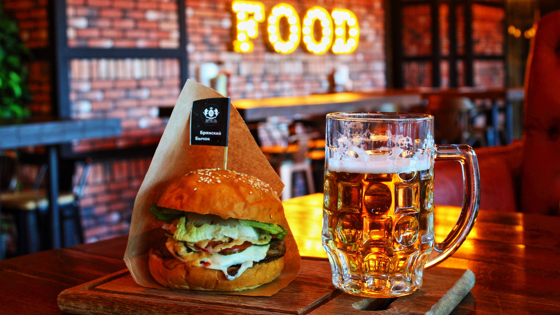 Mesa de bar com hamburguer e caneca de cerveja