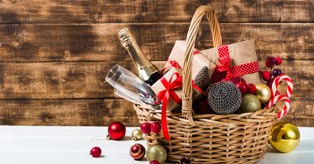 Cesta de Natal para funcionários com presentes, frutas, espumante, taças e decorações.