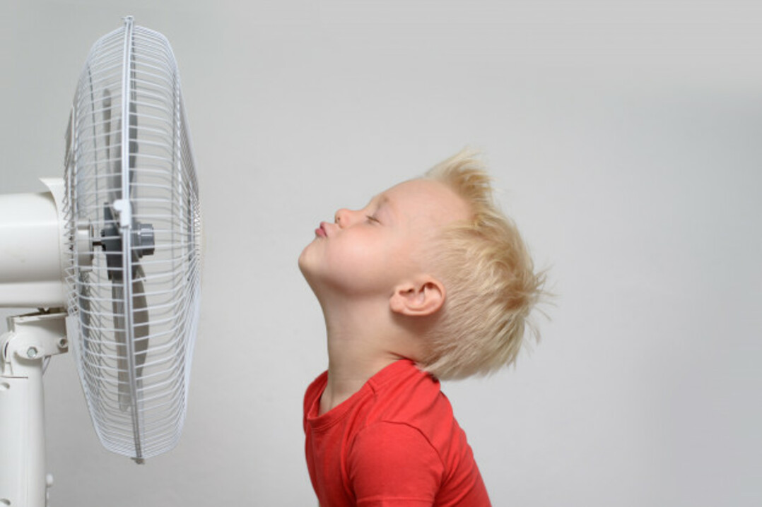 Criança se refrescando em frente ao ventilador
