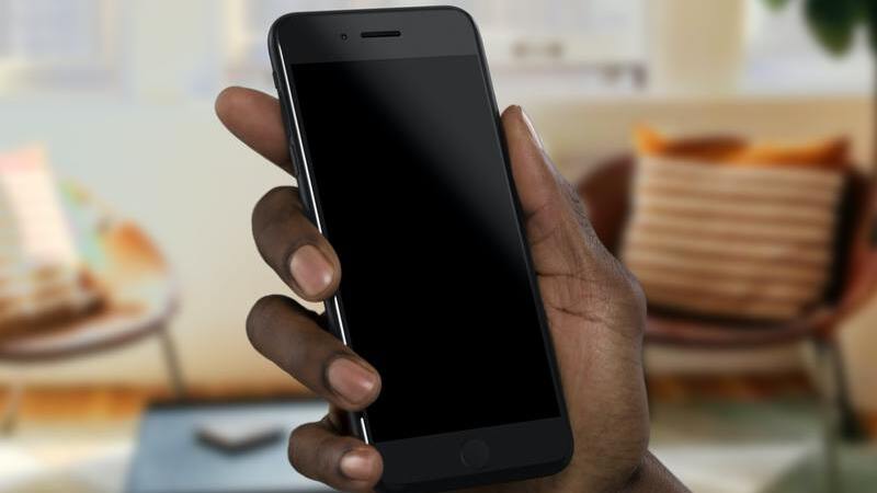 mão humana segurando smartphone com a tela desligada