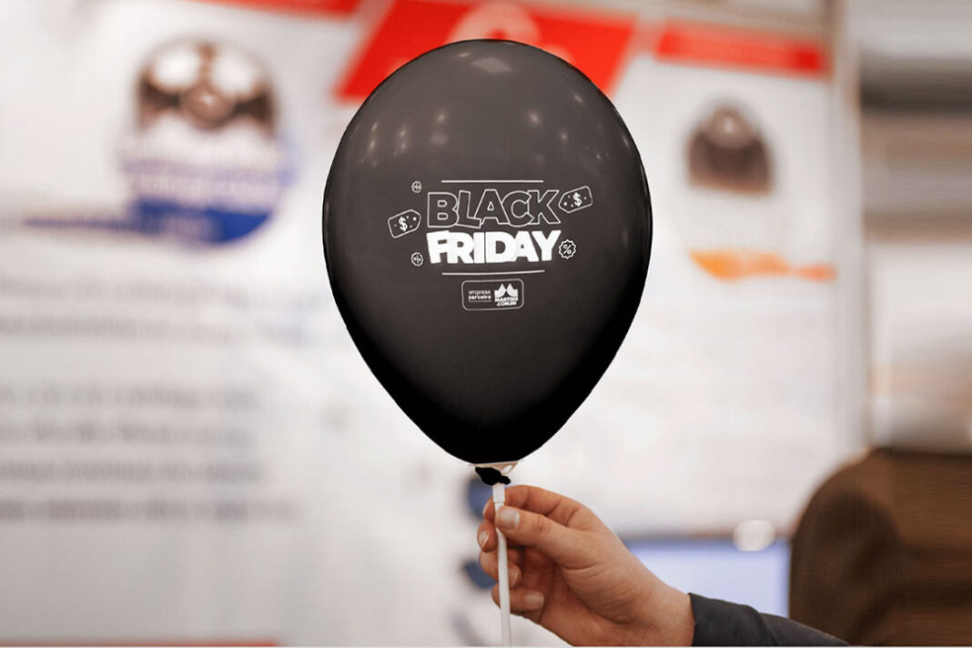 mão segurando balão preto com escrito da Black Friday