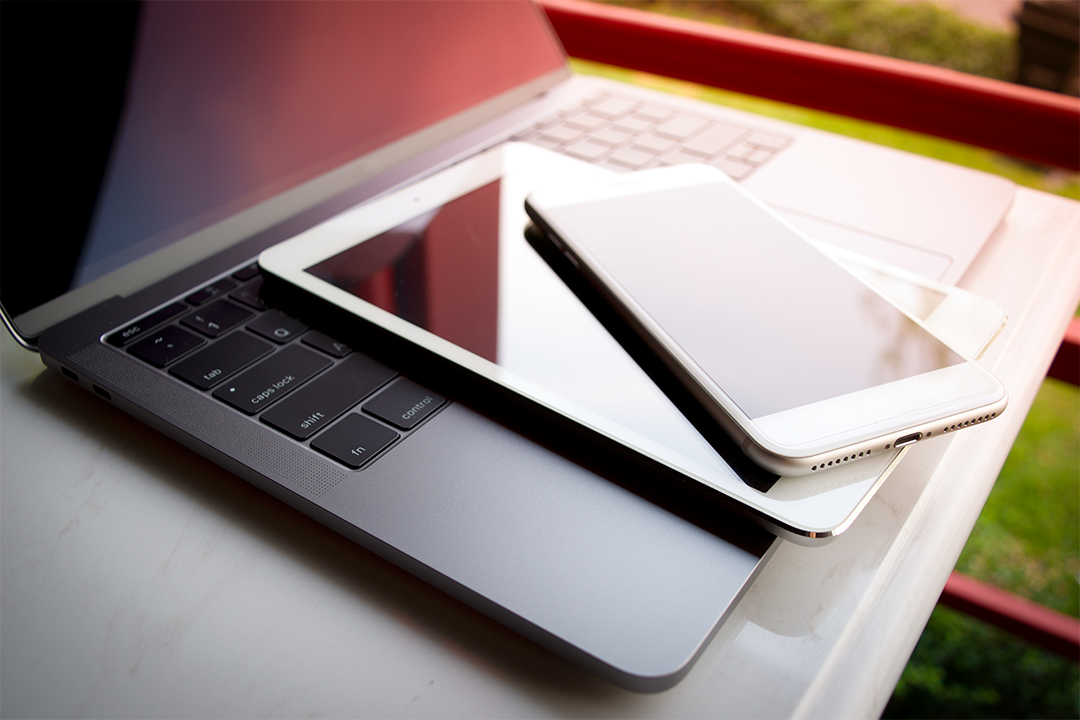 aparelhos eletrônicos como notebook tablet e celular em cima de mesa