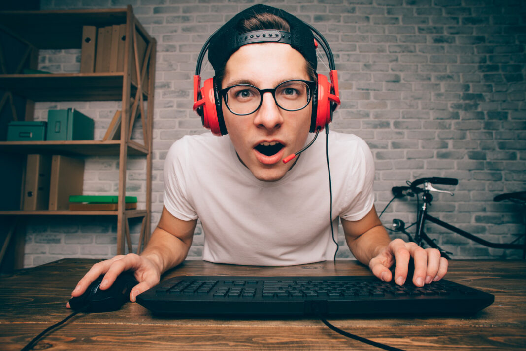 jovem de óculos com fone de ouvido usando teclado e mouse